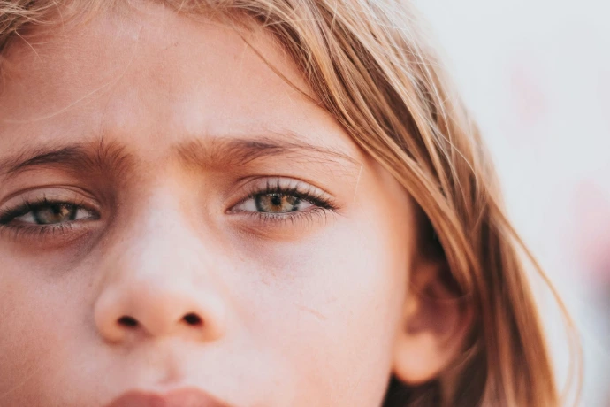 Close-up of a young girl's face with green eyes.